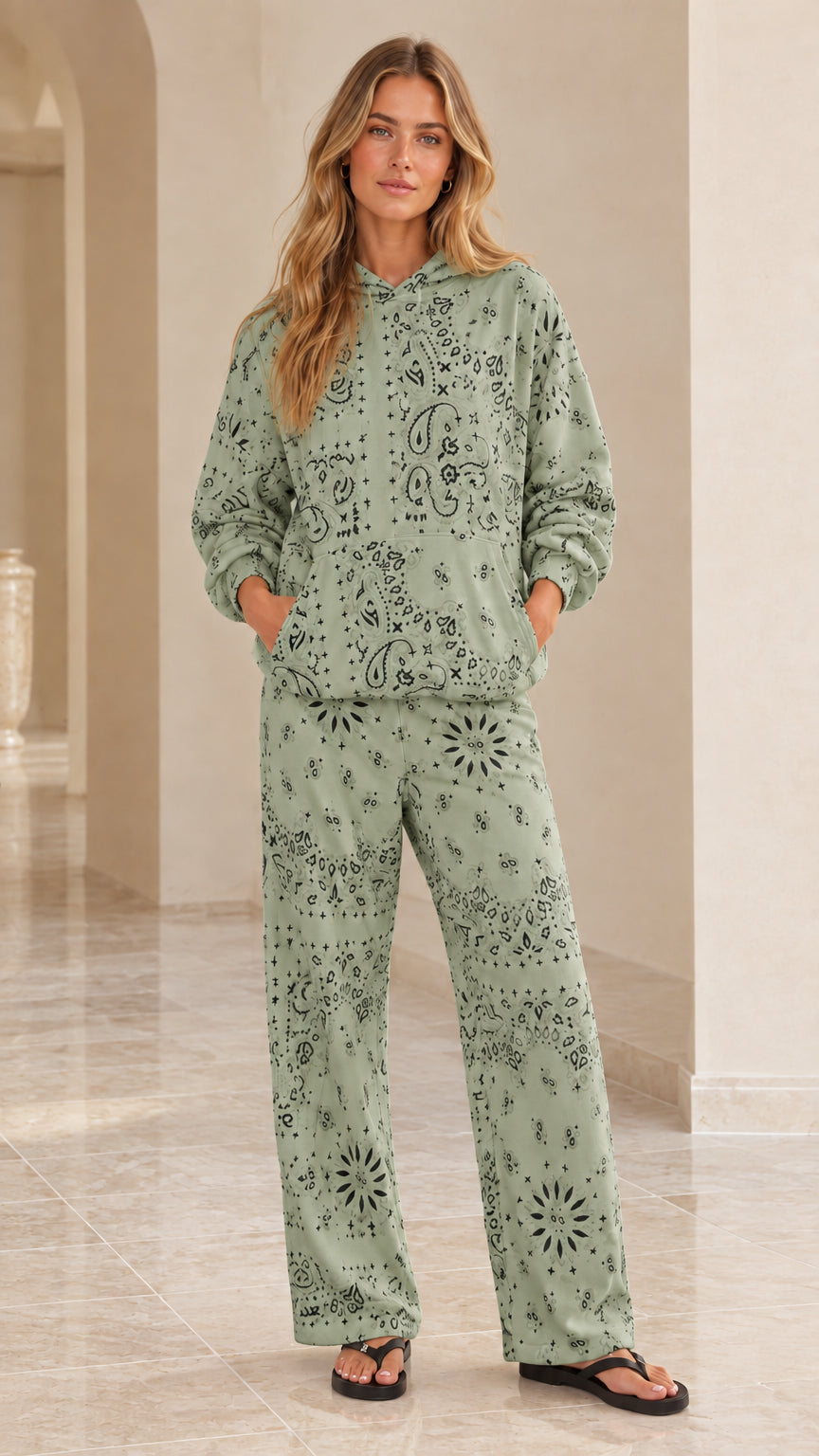 Full-body view of woman wearing sage green bandana paisley print hoodie and pants set