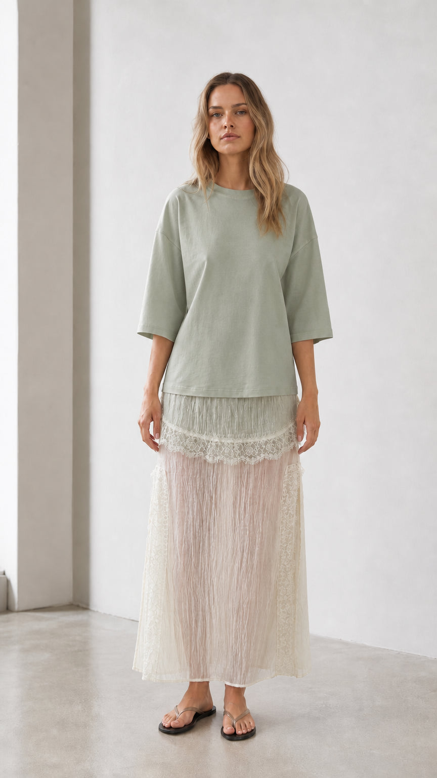 Front view of woman wearing sage green relaxed tee and matching skirt set