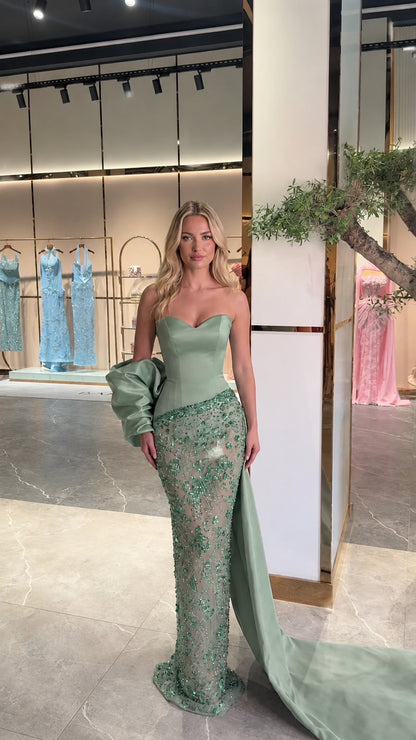 Model wearing sage green strapless crystal embellished evening gown with side train