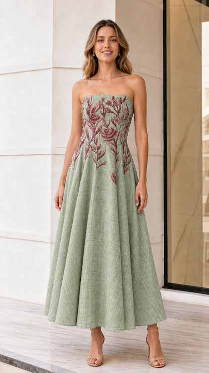 Front view of model wearing sage green strapless embroidered midi dress