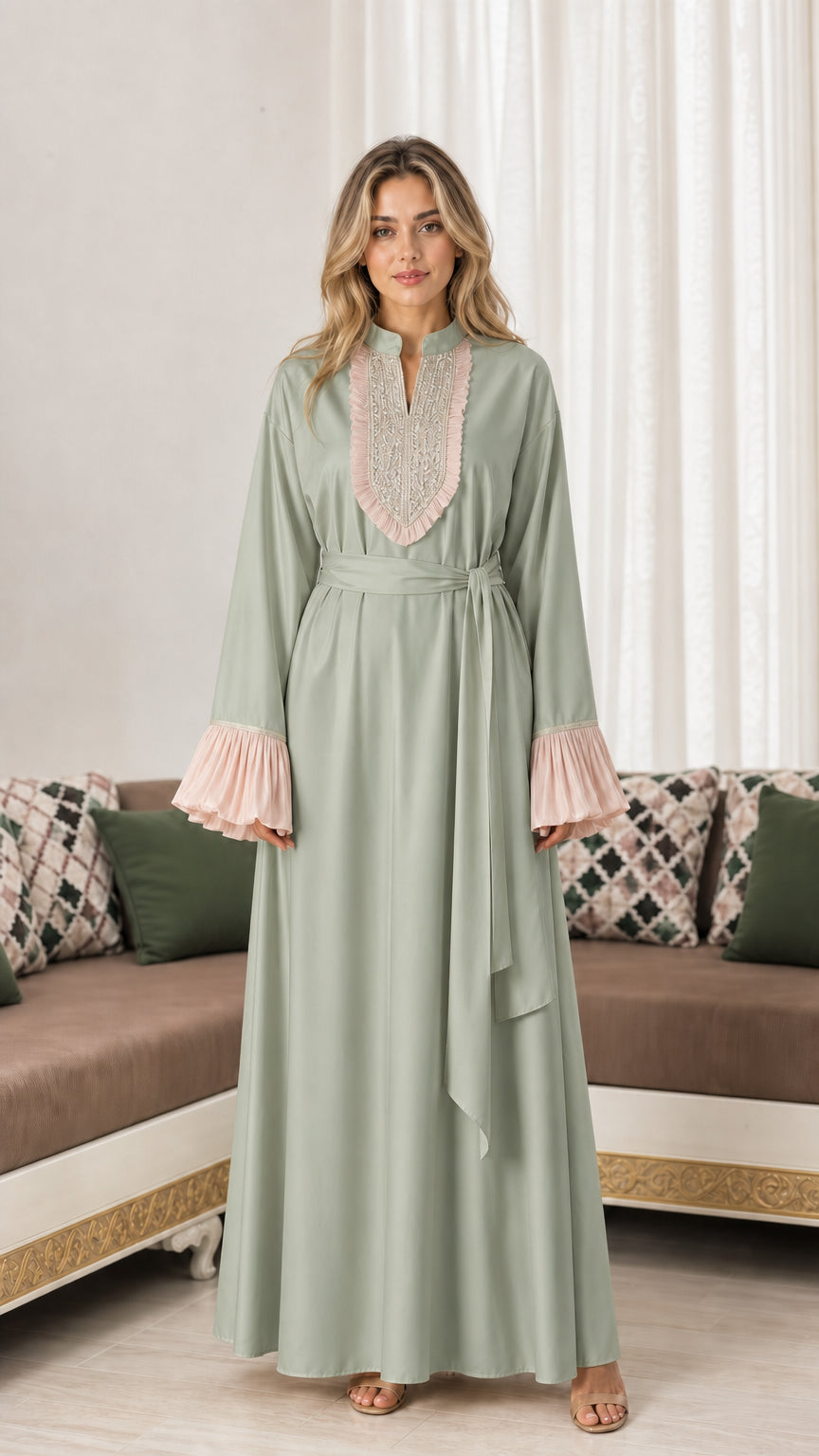 Front view of woman wearing sage green embroidered maxi abaya dress with pleated cuffs