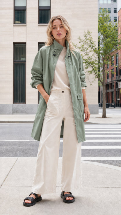 Front view of woman wearing sage green mid-length utility parka coat