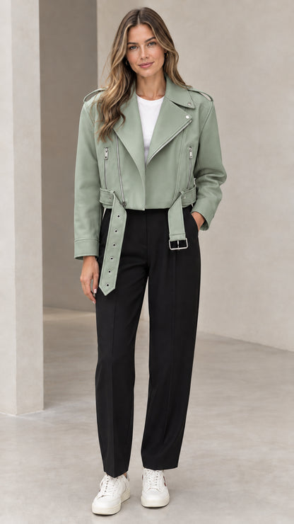 Front view of woman wearing sage green cropped faux leather moto biker jacket