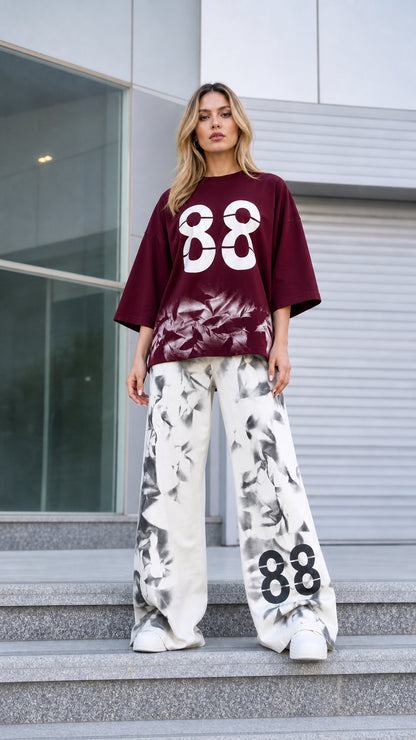 Front view of woman wearing burgundy graphic tee and matching printed wide-leg pants