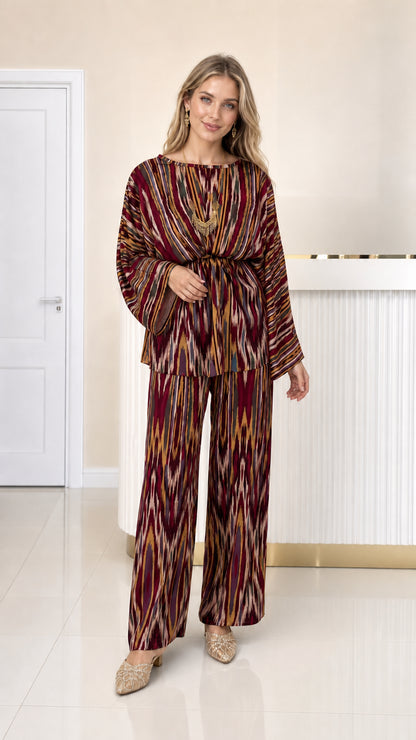 Front full view of woman wearing burgundy wine ikat print pleated matching set