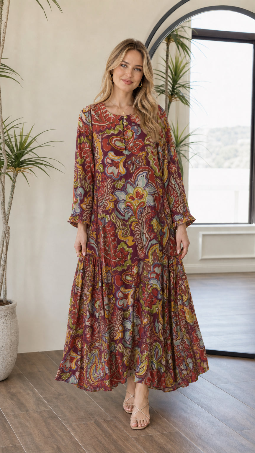 Front view of woman wearing burgundy multi paisley tiered long sleeve maxi dress