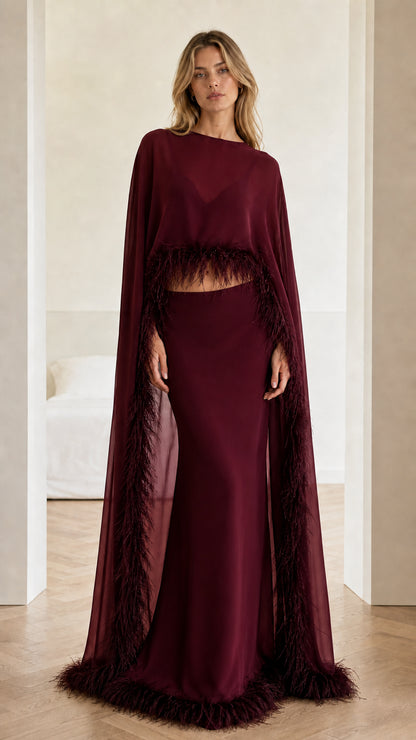 Full-length view of burgundy red feather-trim cape evening gown set
