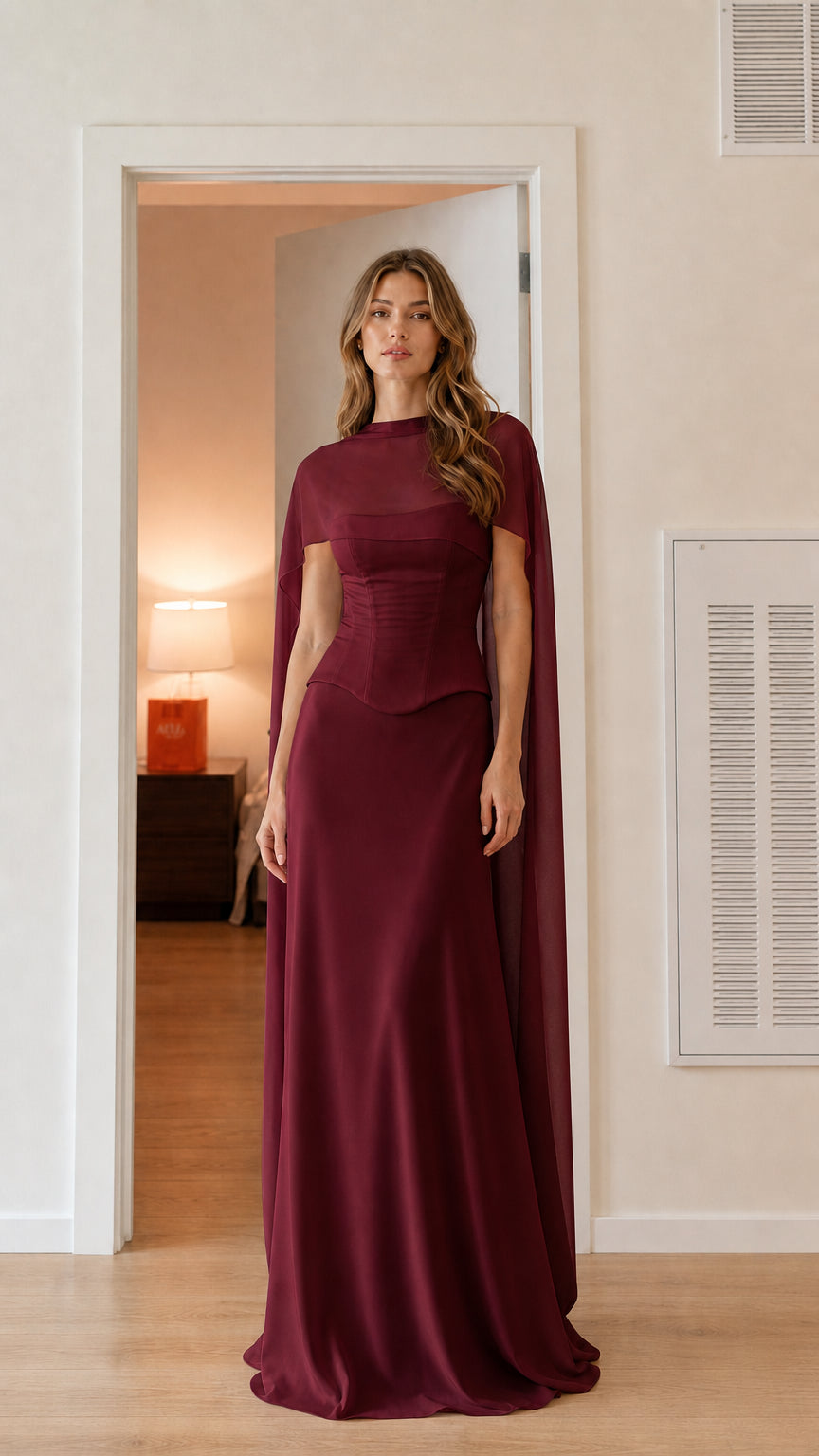 Front view of burgundy wine corset evening gown with sheer cape