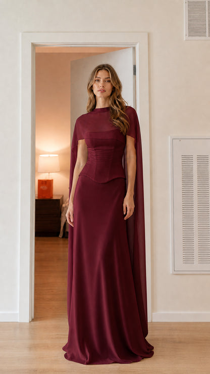 Front view of burgundy wine corset evening gown with sheer cape