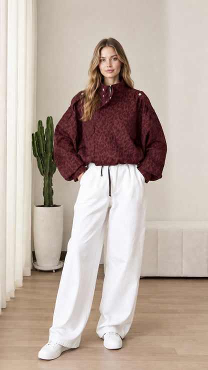 Front view of model wearing burgundy red leopard print half-zip pullover jacket