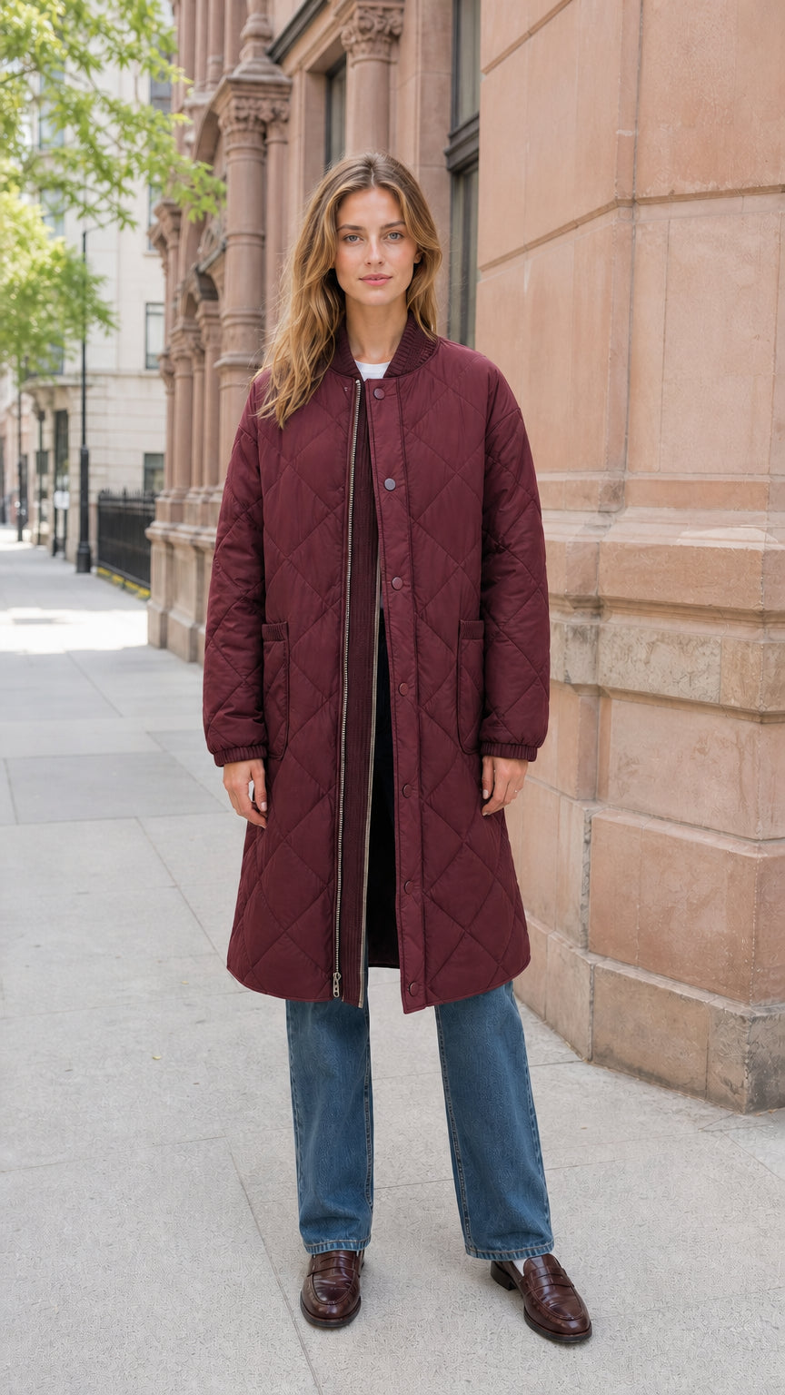 Front view of model wearing burgundy longline quilted bomber jacket