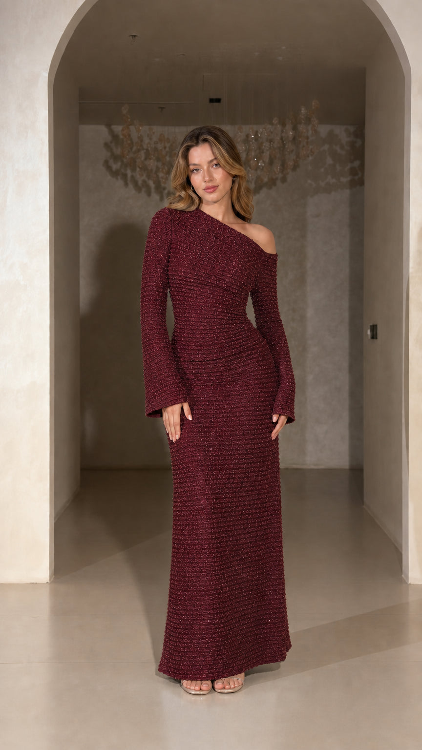Model wearing Burgundy one-shoulder long sleeve textured evening gown