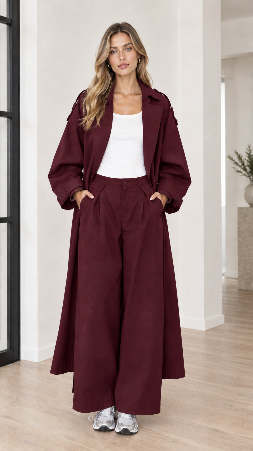 Woman wearing deep burgundy wine oversized maxi trench coat and matching pants set