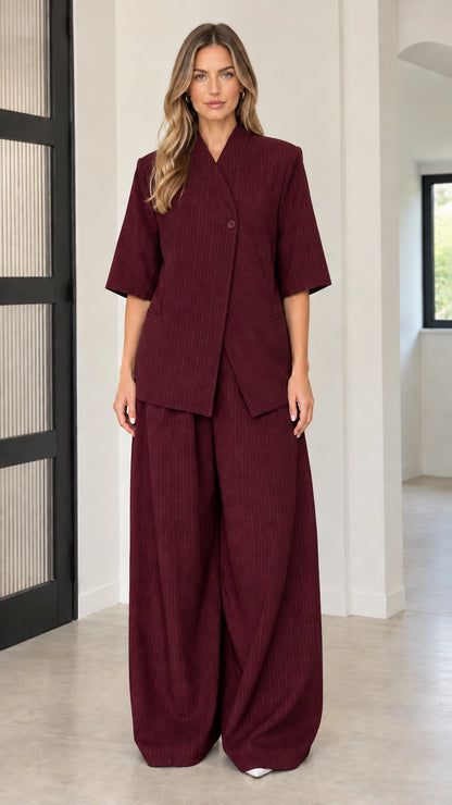 Front full-length view of model wearing Burgundy asymmetric blazer and pant set