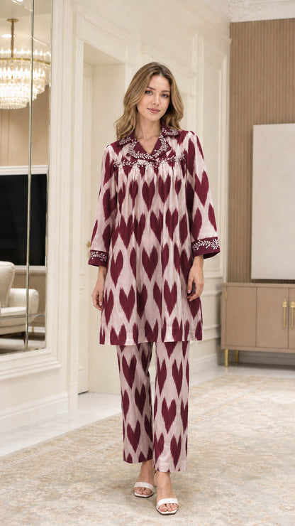 Front view of model wearing Burgundy embellished collar ikat print tunic and pants set