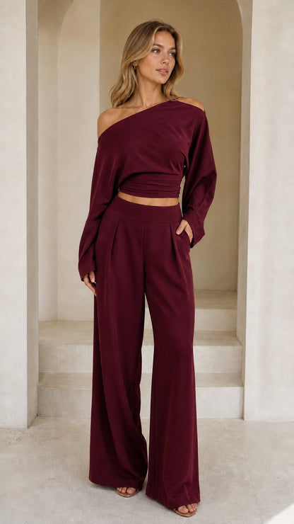Full front view of model wearing burgundy off-shoulder crop top and wide-leg pant set