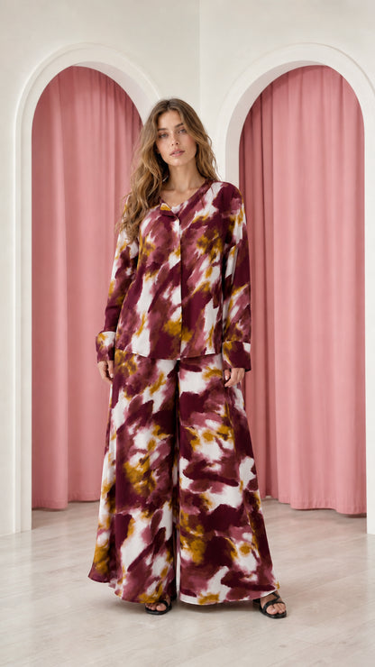 Model wearing burgundy tie-dye satin top and wide-leg trousers set