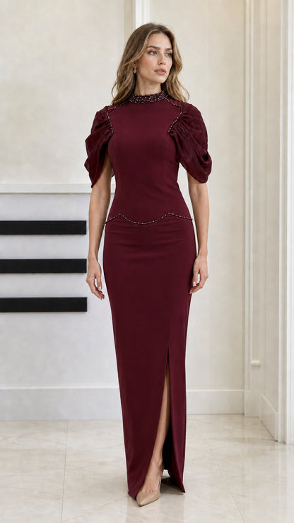 Front view of woman wearing Burgundy beaded high-neck puff sleeve evening gown