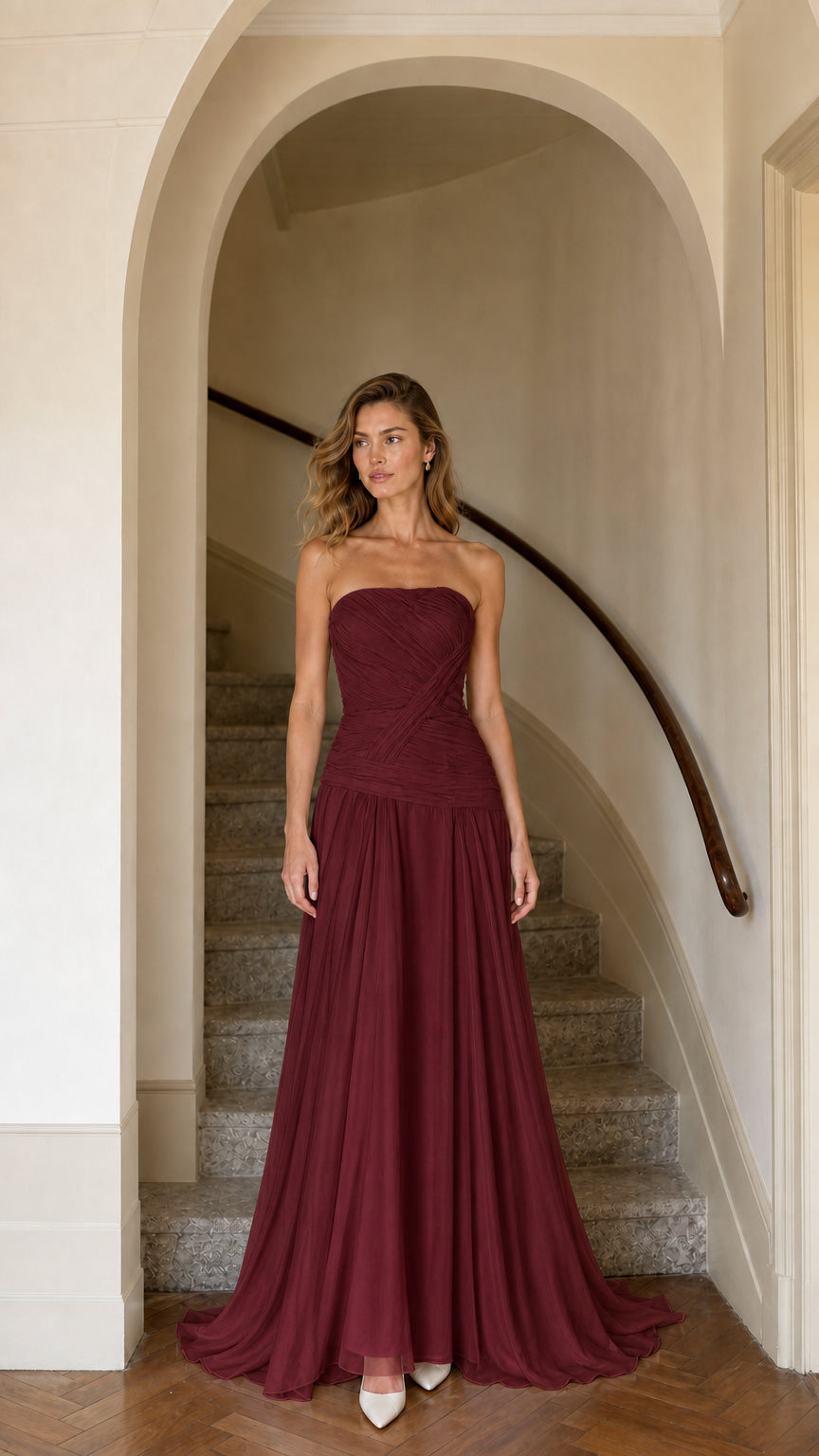 Model wearing burgundy red strapless pleated maxi bridesmaid dress