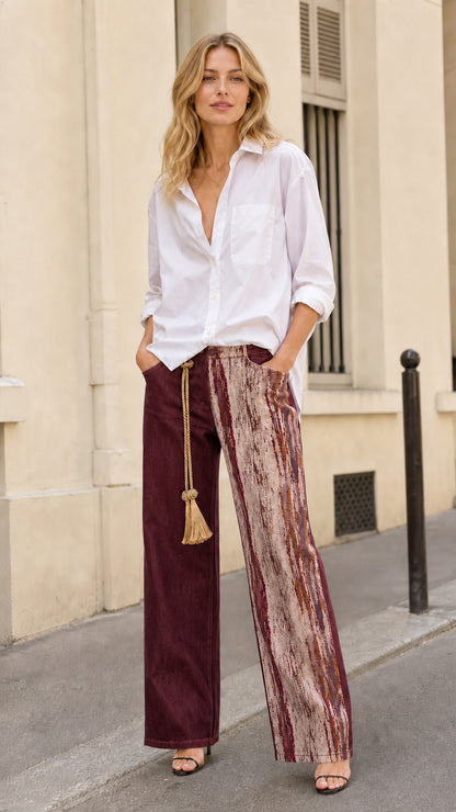 Model wearing burgundy wine red contrast printed panel wide leg trousers