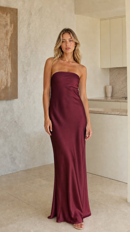 Model wearing deep burgundy strapless satin maxi dress