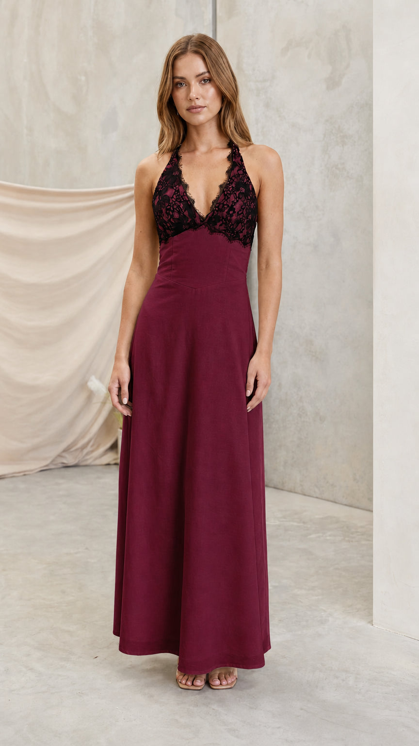 Model wearing burgundy wine halter maxi dress with dark lace bust