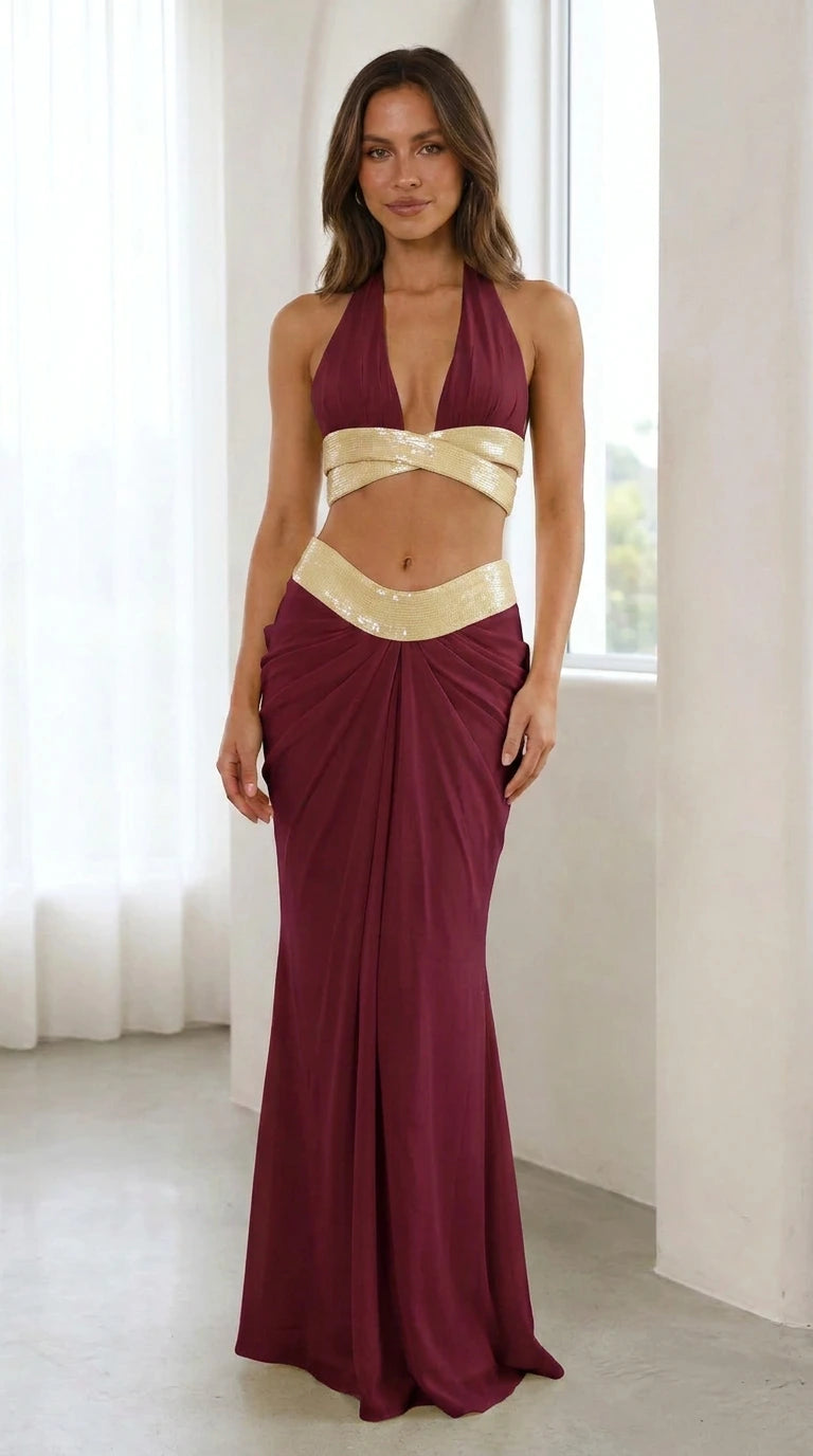 Model wearing burgundy sequin halter two-piece maxi dress