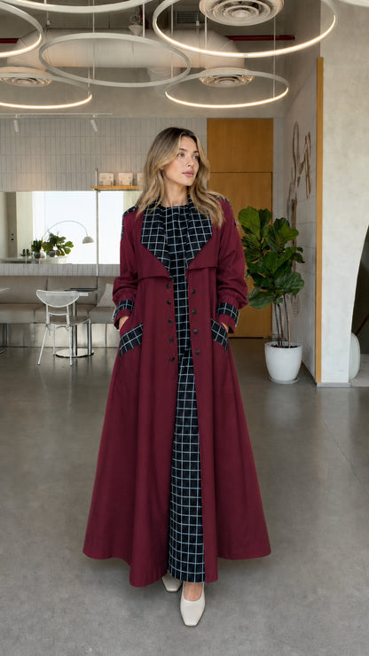 Full front view of model wearing burgundy wine red maxi trench coat with grid plaid details