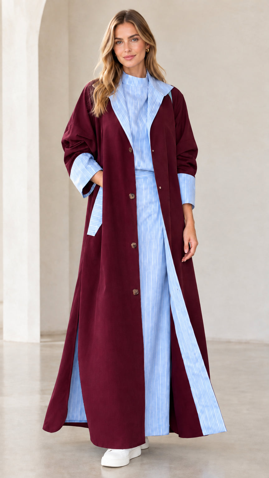 Women's burgundy longline trench coat with contrast blue striped collar and pleat