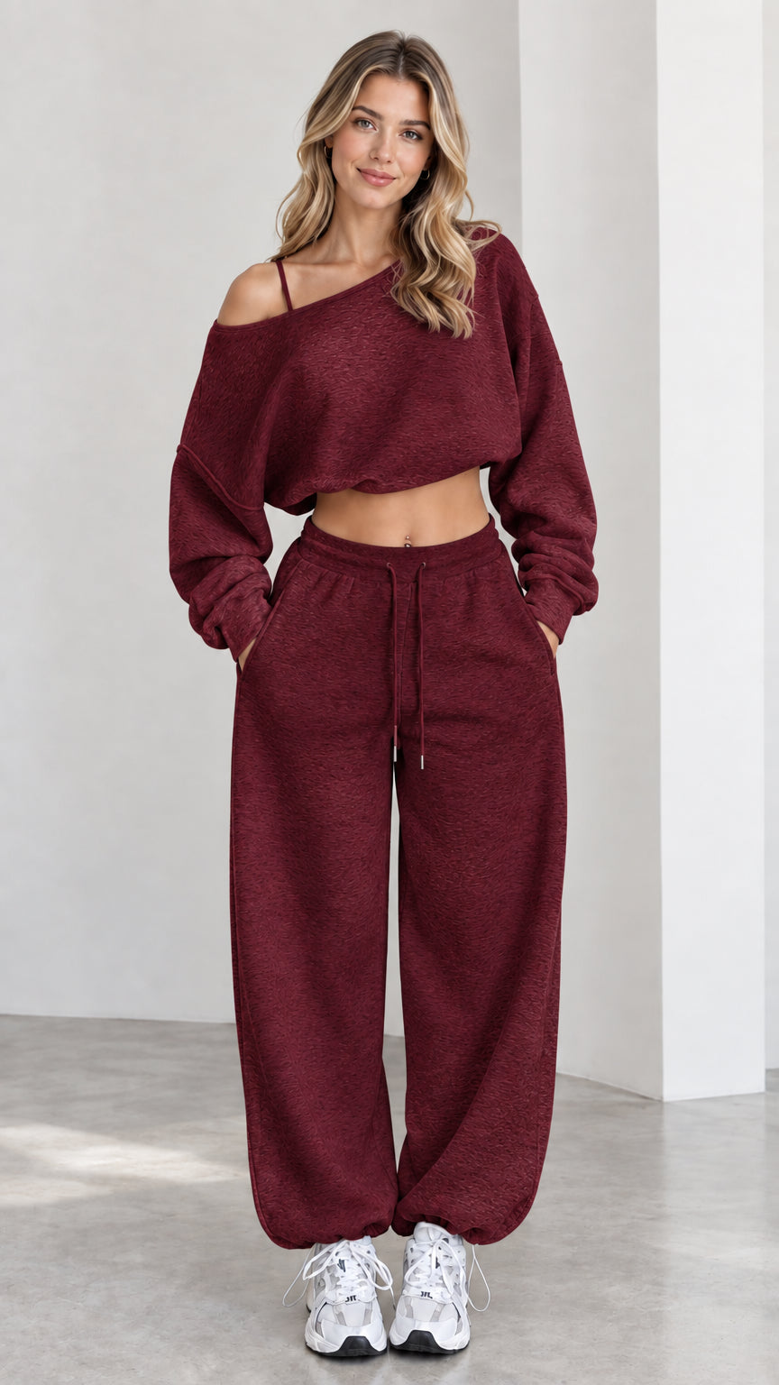 Model wearing burgundy off-the-shoulder cropped sweatshirt and sweatpants loungewear set