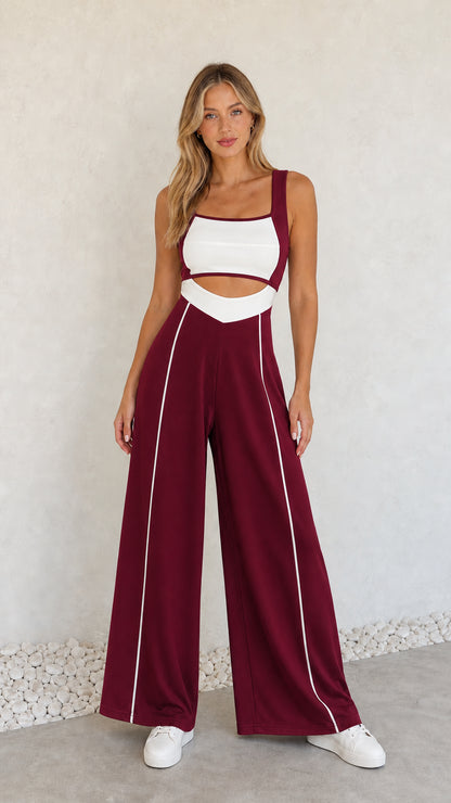 Model wearing burgundy colorblock cutout wide-leg jumpsuit with white piping
