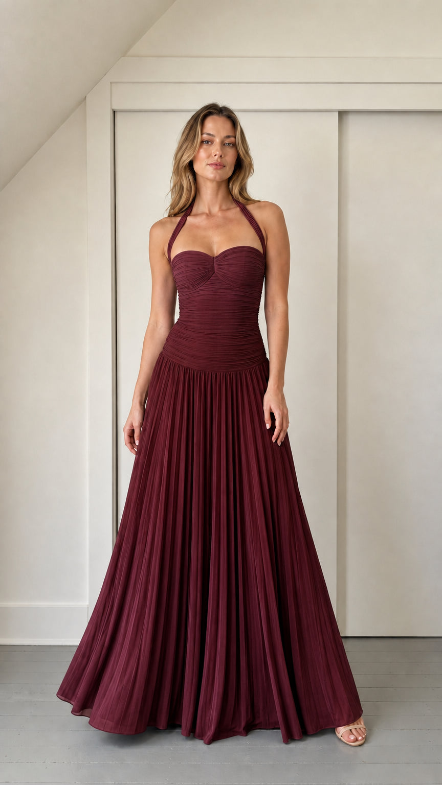 Model wearing burgundy ruched halter maxi dress