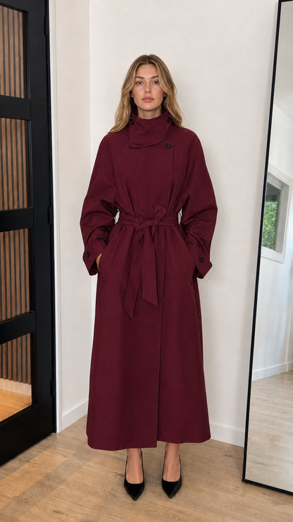Front view of model wearing a burgundy wine red high neck belted longline trench coat