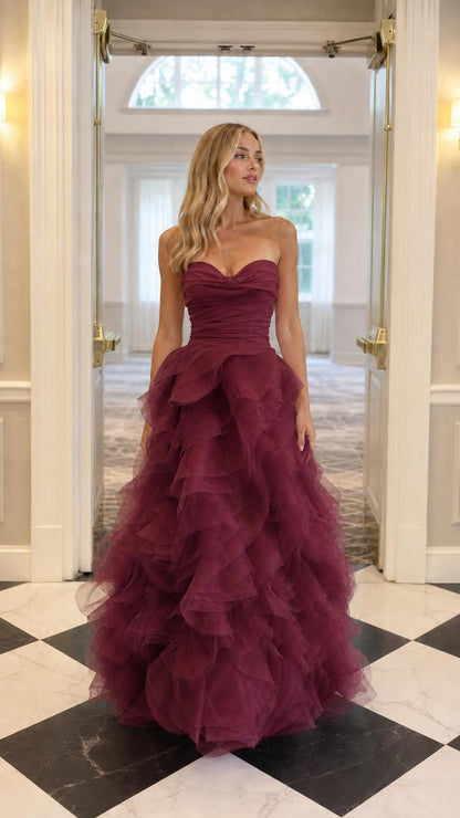 Model wearing burgundy strapless tulle ball gown evening dress