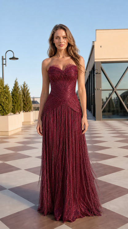 Front view of model wearing burgundy wine red strapless fringe maxi gown