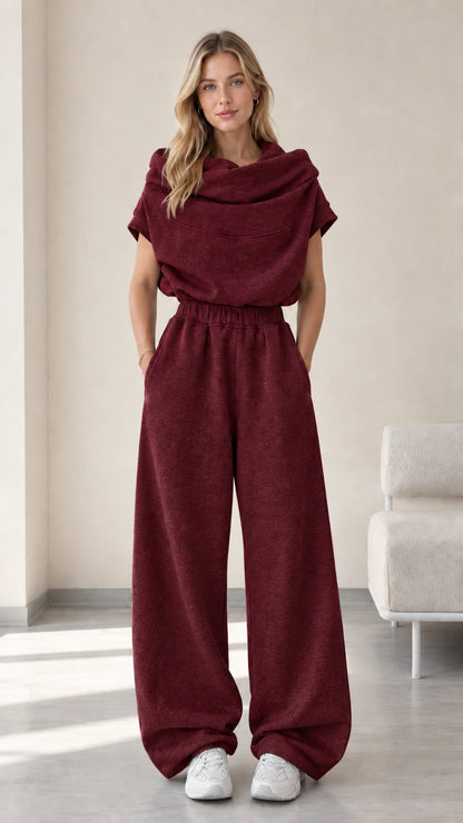 Full-length studio view of model wearing burgundy wine red cowl neck top and wide-leg pants set