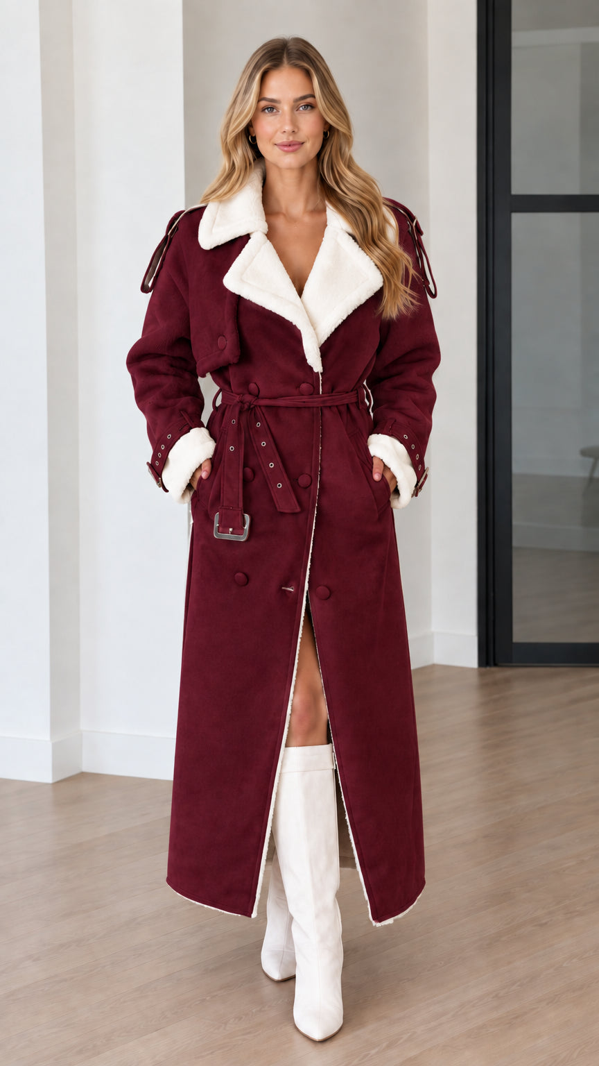 Model wearing a burgundy faux shearling lined belted maxi trench coat