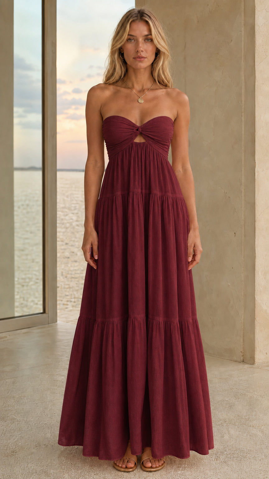 Front view of a burgundy strapless tiered maxi dress