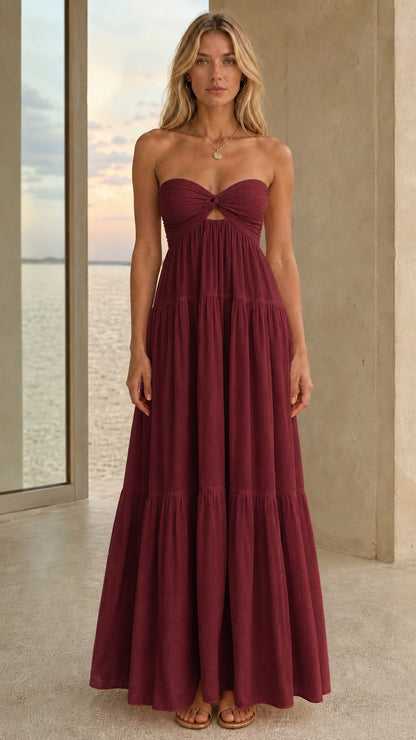 Front view of a burgundy strapless tiered maxi dress