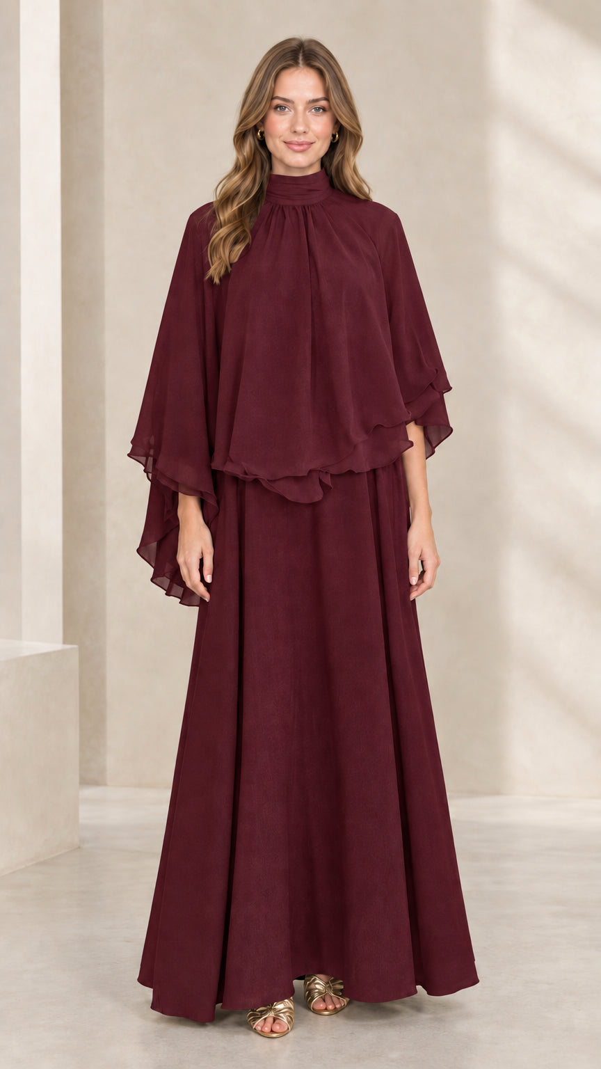 Front view of woman wearing burgundy mock neck capelet maxi dress