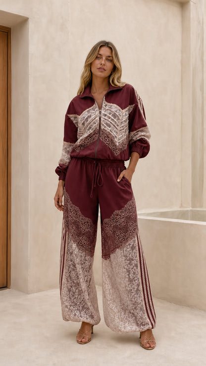 Front view of woman wearing burgundy lace patchwork track set