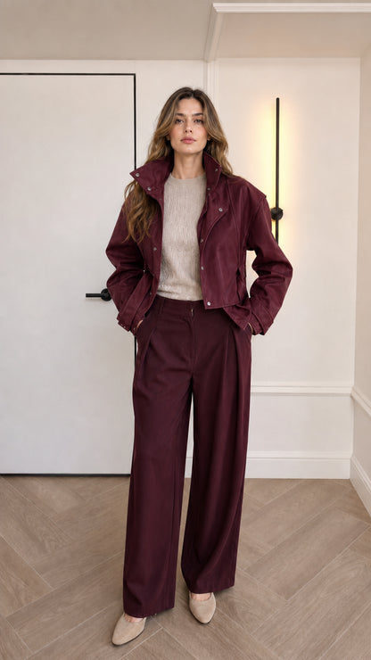 Model wearing burgundy red cropped faux leather jacket with matching trousers