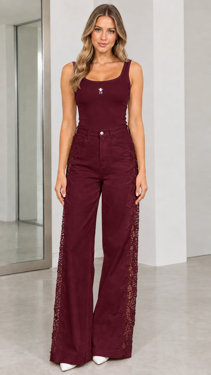 Front view of model wearing burgundy high-waisted wide-leg pants with lace side panels