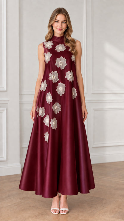 Model wearing burgundy sleeveless high neck maxi dress with white floral appliqués