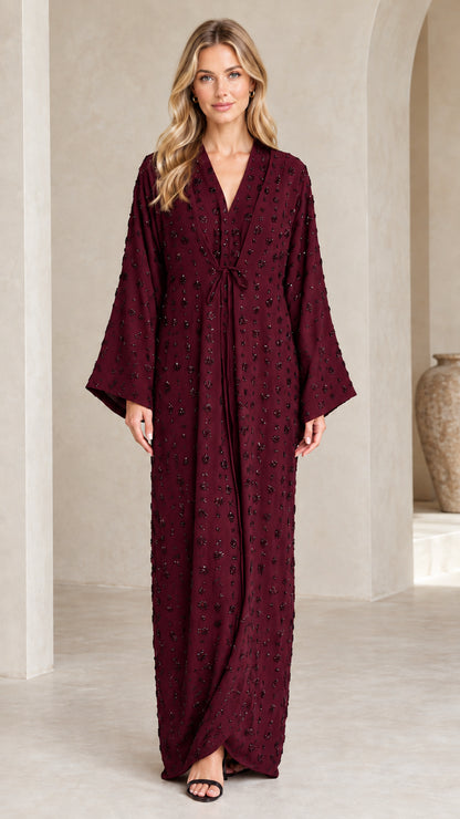 Front view of woman wearing Burgundy wine-toned embellished formal maxi dress