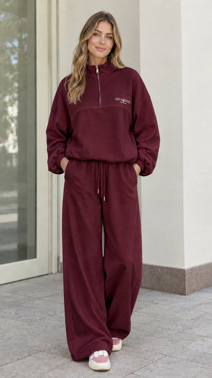 Woman wearing Burgundy fleece quarter-zip pullover and matching wide-leg pants set