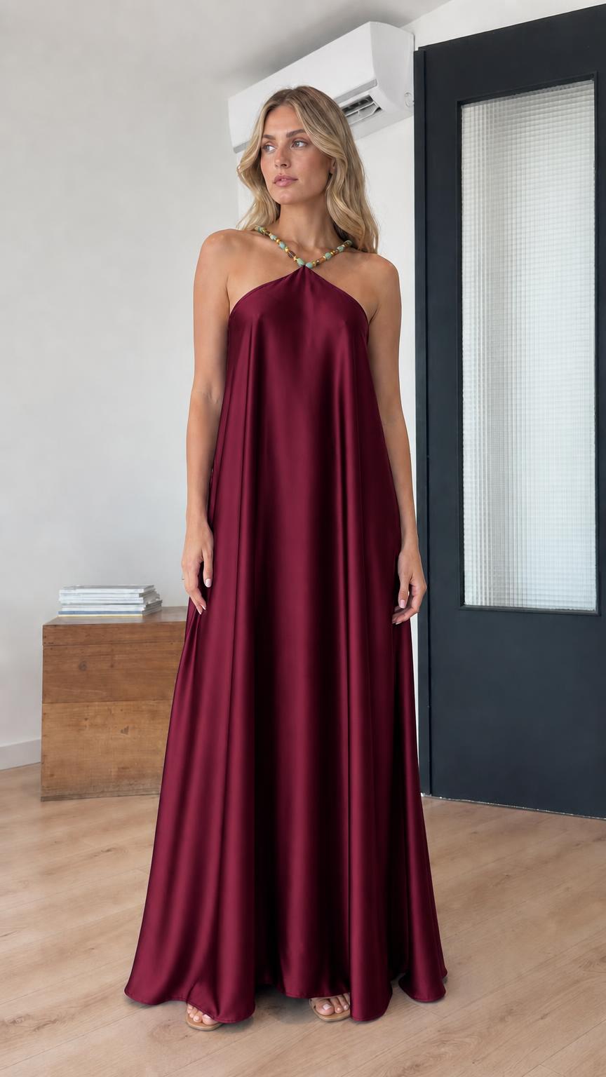 Model wearing burgundy satin halter maxi dress