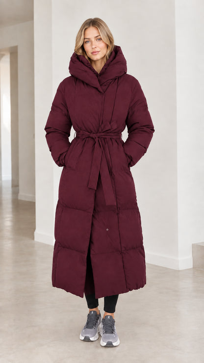Front view of model wearing deep burgundy red long belted puffer parka