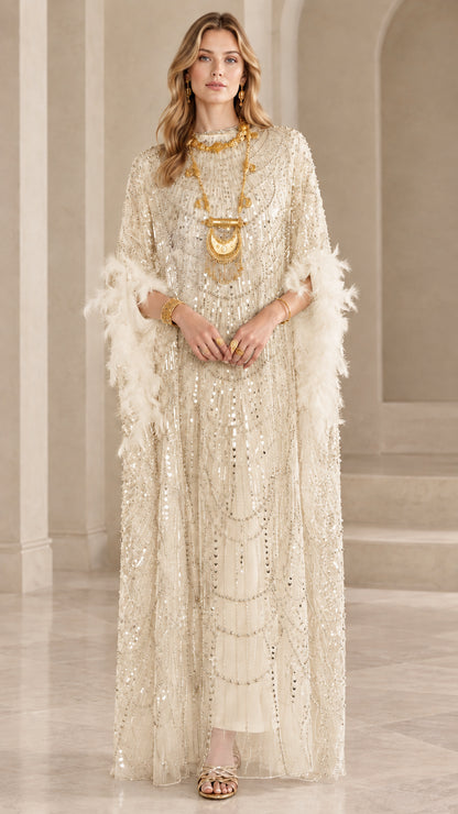 Model wearing champagne gold sequin kaftan maxi dress with feather trim