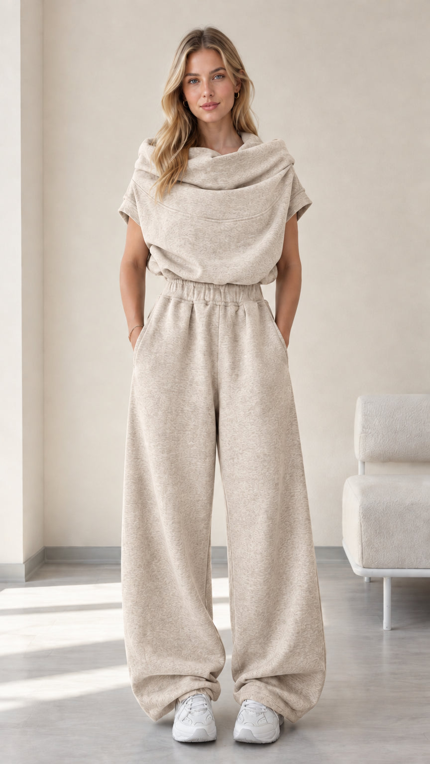 Full-length studio view of model wearing oatmeal beige cowl neck top and wide-leg pants set